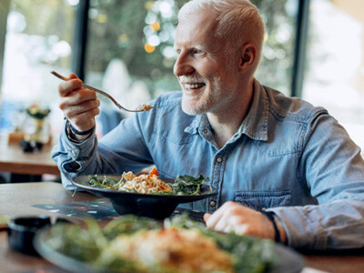 Senior man smiling and eating a meal