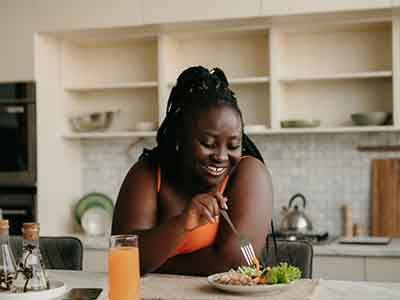 a woman resting on a countertop eating lunch