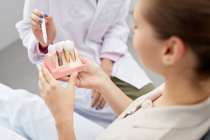 Dentist explaining dental implants while patient holds a model